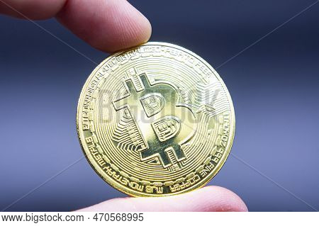 Finger Hold Bitcoin Golden On Black Isolated. Hand Hold Gold Bitcoin Crypto Ditital Money Concept. O