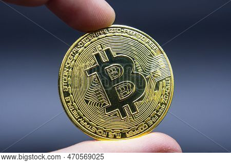 Finger Hold Bitcoin Golden On Black Isolated. Hand Hold Gold Bitcoin Crypto Ditital Money Concept. O