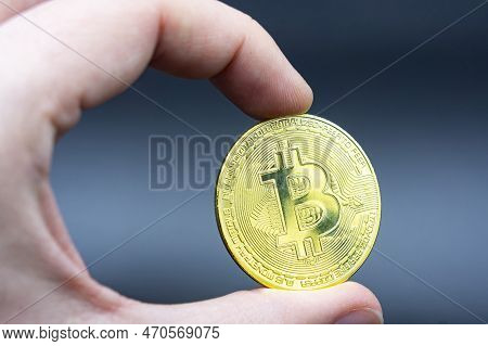 Finger Hold Bitcoin Golden On Black Isolated. Hand Hold Gold Bitcoin Crypto Ditital Money Concept. O