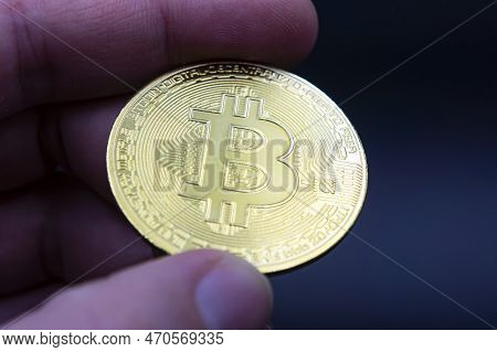 Finger Hold Bitcoin Golden On Black Isolated. Hand Hold Gold Bitcoin Crypto Ditital Money Concept. O