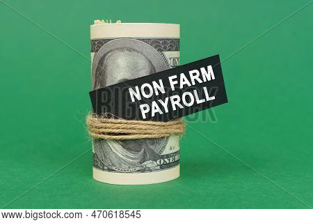 Business Concept. On A Green Surface, Rolled Dollars With A Black Sign That Says - Non Farm Payroll