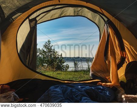 View From The Tent To The River. Hiking Concept. Dawn In A Tent. No People. Tourists. Orange Awning.