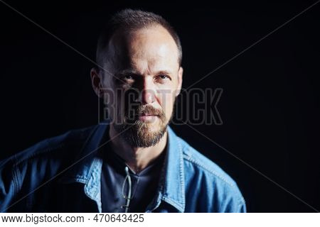 Concentraited Middle Age Man In Denim Shirt Looking Squinting At Camera