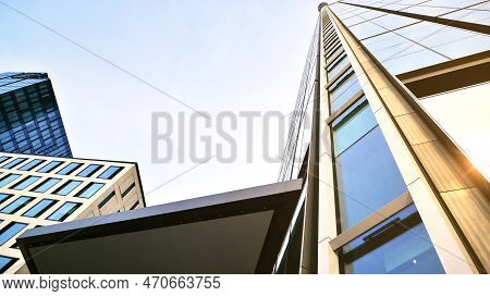 Bottom View Of Modern Skyscrapers In Business District Against Blue Sky. Looking Up At Business Buil