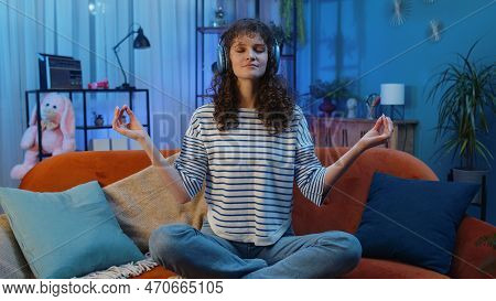 Keep Calm Down, Relax. Woman With Curly Hairstyle At Home Couch Breathes Deeply With Mudra Gesture, 