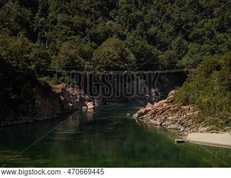 Downstream View Of Multiple People Crossing Longest Buller Gorge Swing Bridge Spanning 110 M Over Bu