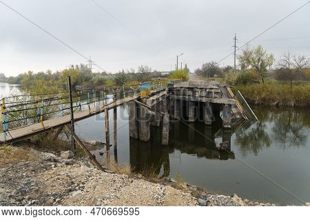 Destroyed Bridge Across The River. War In Ukraine. Russian Invasion Of Ukraine. Destruction Of Infra