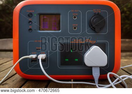 Close Up Of Portable Power Station Solar Electricity Generator Outdoors On Wooden Table With Electro