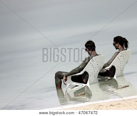 Young Caucasian  Couple Taking Mud Treatment on the Dead sea beach