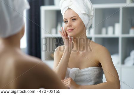 Young Woman Sits In The Bathroom In Front Of The Makeup Mirror And Does Cosmetic Procedures. Beautif