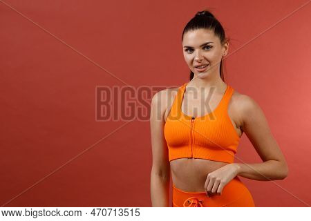 Young Positive Smiling Woman In Orange Fitness Sport Outfit Cloth Studio Isolated Shot.