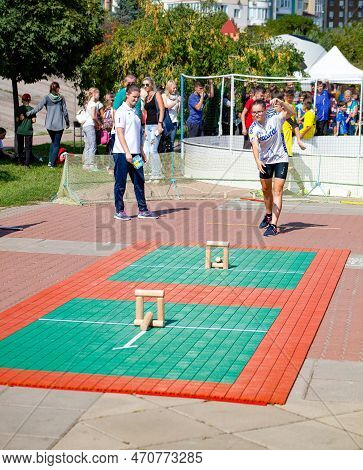 People Play The Game Gorodki. Wooden Chocks Need To Be Knocked Down With A Stick. Aim Of Game Is To 