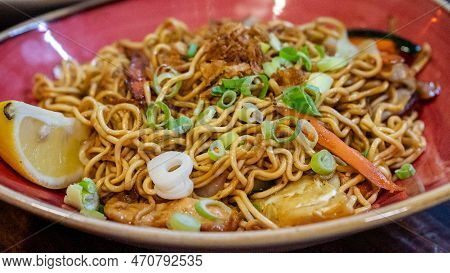 A Close Up Image Of Freshly Prepared Oriental Style Stir Fried Noodles Served In A Red Bowl