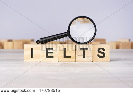 Wooden Blocks With A Magnifying Glass Text: Ielts. International English Language Testing System