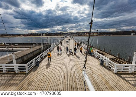 Sopot, Poland - April 2022: Beautiful Long Wooden Pier With Lamps On Both Sides And Walking People