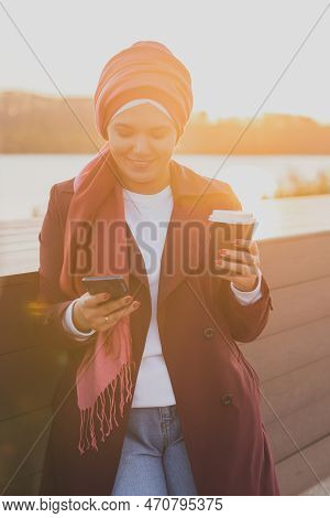 Modern Arab Girl In Hijab Walking By Street And Drinking Coffee Take Away In Spring Time Morning