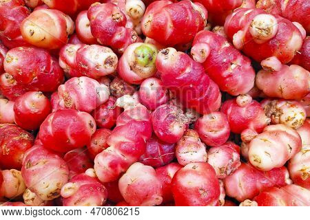 Close-up On A Stack Of Pink Oca (oxalis Tuberosa) On A Market Stall. Oxalis Tuberosa Is A Perennial 