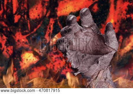 Zombie Hand With Peeling Skin On A Dark Fiery Background. The Concept Of Punishment In Hell. Hallowe