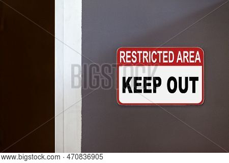 Red And White Restricted Area Sign On The Side Of An Open Door Stating : Restricted Area, Keep Out.