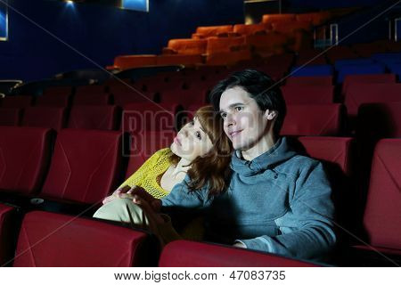 Giovane uomo e Guarda il film donna, abbraccio e sorriso nel teatro cinema.