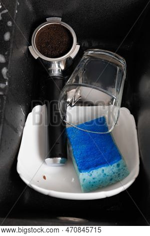 Washing Dishes Concept. Dirty Dishes With Foam From Detergent In A Black Stone Sink In The Kitchen T