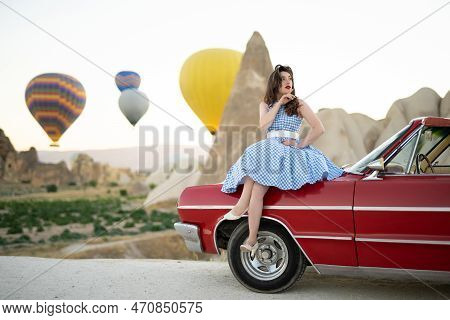 Beautiful Girl In Retro Style Posing Near A Vintage Red Cabriolet Car On Background Of Balloons In C