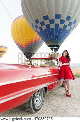 Beautiful Girl In Retro Style Posing Near A Vintage Red Cabriolet Car On Background Of Balloons In C