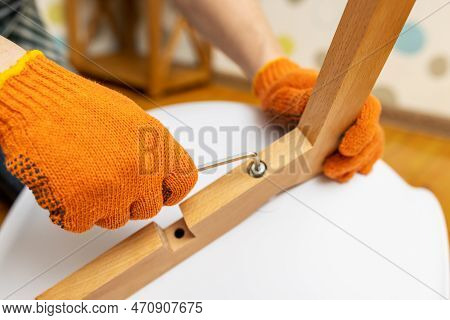 Self-assembly Furniture Concept. The Young Man Himself Assembling Chairs