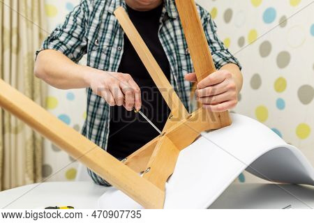 Self-assembly Furniture Concept. The Young Man Himself Assembling Chairs