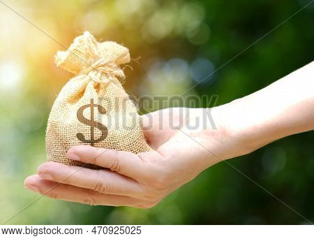 Man's Hand Holding A Wallet And Giving A Bag Of Money, Money Saving And Investment Concept