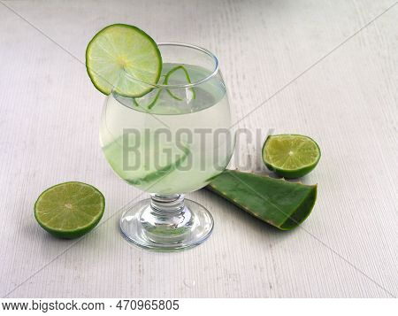 Detox Water Of Aloe Vera And Lemon Juice. Healthy Drink And Slices Of Lime And Sabila On White Backg