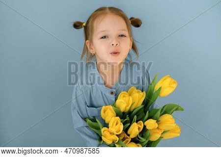 A Sweet Gentle Girl With Tails Holds A Bouquet Of Yellow Tulips As A Gift To Her Mother On Mother's 