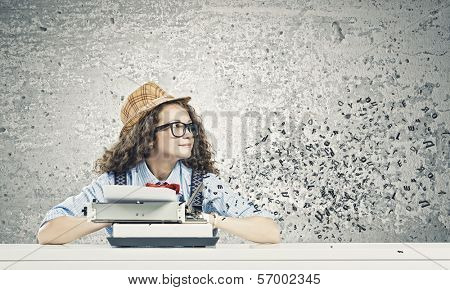 Young funny woman in glasses using typewriter