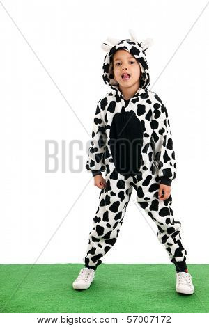 Little boy dressed as cow sitting in the grass