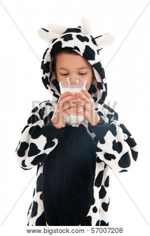 Little boy dressed as cow drinking healthy glass of milk