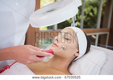 Peaceful brunette getting micro dermabrasion from beauty therapist in the health spa