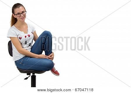 Happy teenager girl with glasses sitting on chair