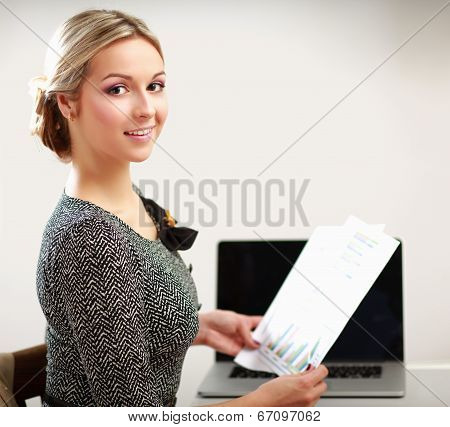 young woman with a laptop sitting isolated on white background