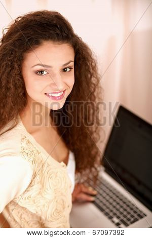 young woman with a laptop sitting isolated on white background