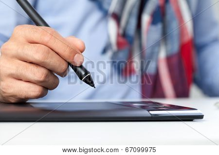 Hand of graphic designer on graphics tablet
