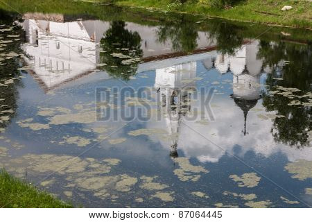 A reflection of a church in a pond. In the Spaso-Prilutsky monastery.