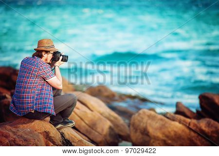 Young photographer taking photos at the beach