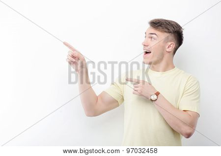 Cheerful man pointing aside on isolated background