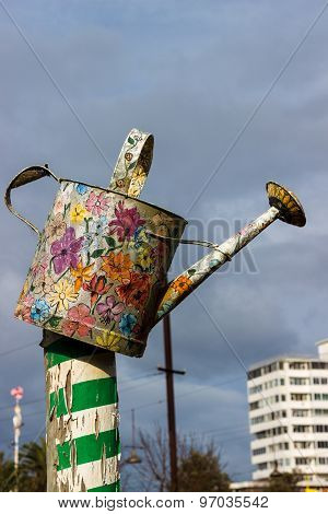An Old Watering Can Painted With Colorful Floral Decorations