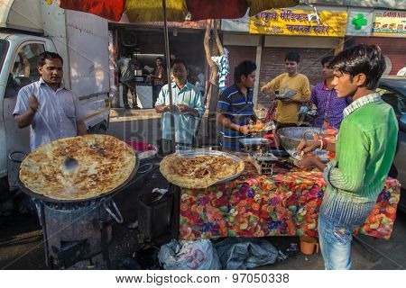 MUMBAI, INDIA - 10 JANUARY 2015: Street vendor makes Halwa poori close to Dhobi Ghat. A sweet bread and type of candy made for breakfast. Customers eat with fingers.