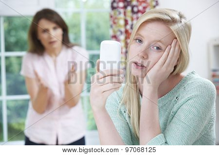 Mother Arguing With Teenage Daughter Over Use Of Mobile Phone