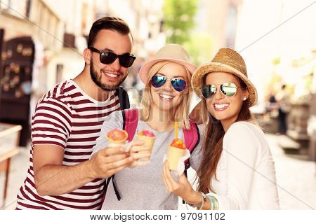 A picture of a group of friends eating ice-cream in the city