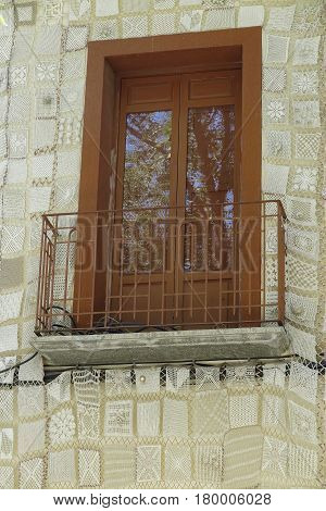 foreground of a balcony on a facade decorated with crochet work