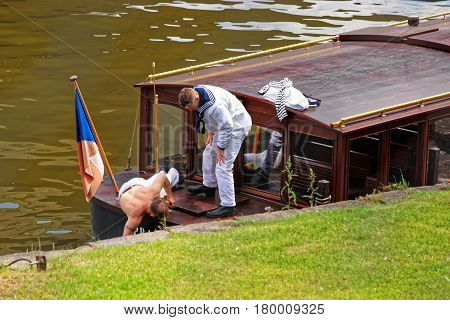 Skipper Repairing Excursion Ferry At Embankment Of Vltava River Prague