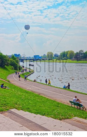 People Relaxing At Embankment Of Visla River Krakow
